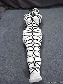 16 of Pretty brunette Ann is wrapped up tightly head to toe in crepe bandages.